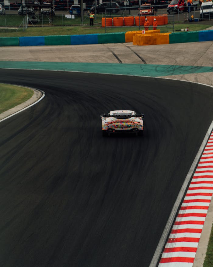 Aston Martin race car speeding on a curved track in an international motorsport event.