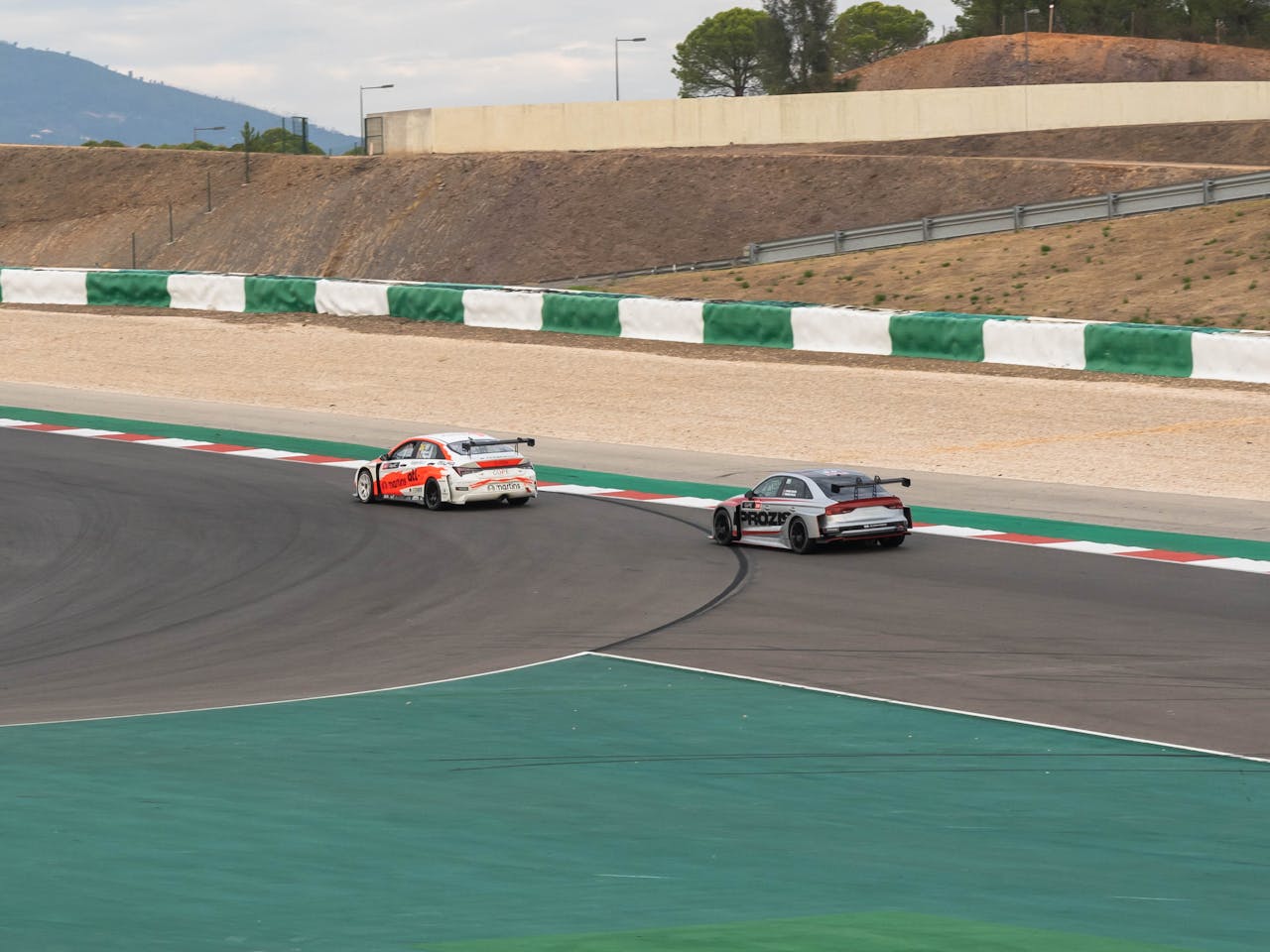 Two high-speed sports cars competing on a race track, showcasing thrilling motorsport action.